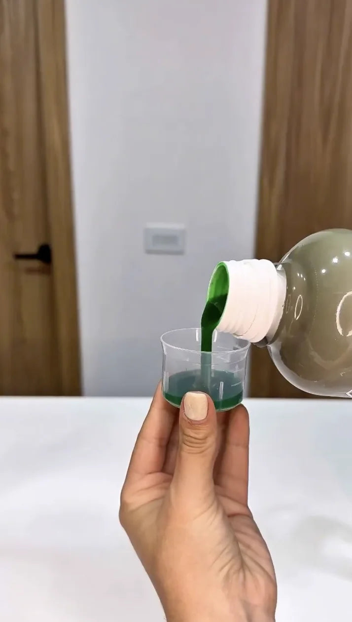 Una mano sirve Clorofull en el vaso medidor