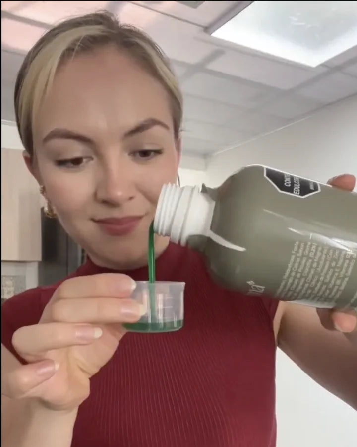 Valentina sirve Clorofull de la botella al vaso medidor