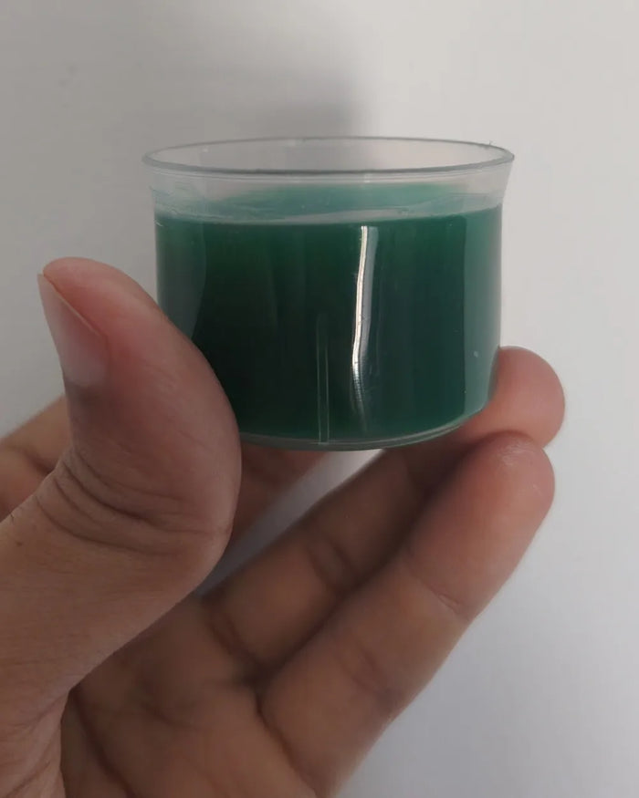El vasito medidor con los 30 ml de Clorofull, de un verde intenso