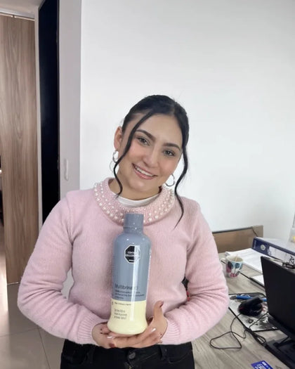 Mujer muestra la botella de Multibrina en su puesto de trabajo