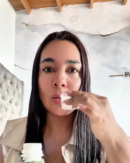 Mujer toma Todo en uno en su vaso medidor