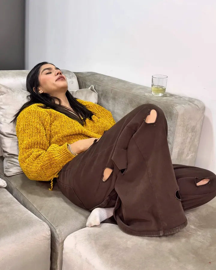 Mujer descansa en el sofá con un vaso de agua al lado